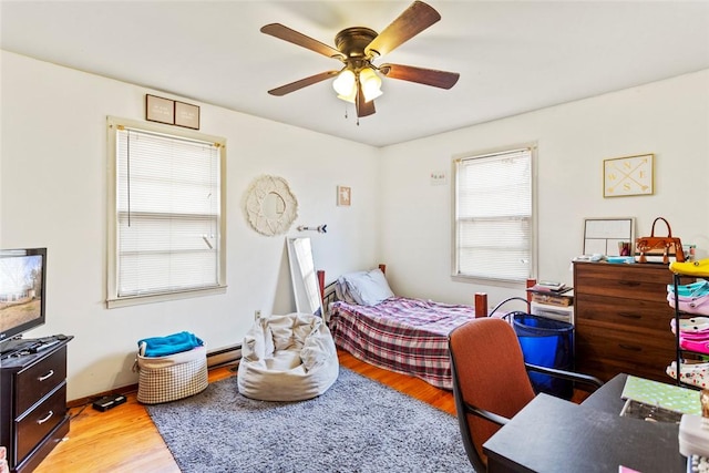 bedroom featuring a baseboard radiator, ceiling fan, and light hardwood / wood-style flooring