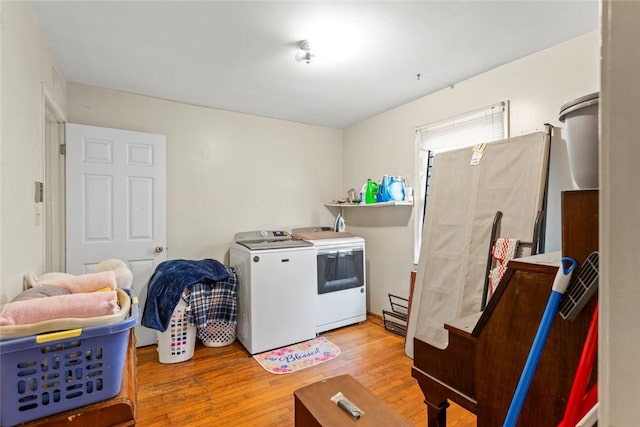 laundry room featuring washer and clothes dryer and light hardwood / wood-style flooring