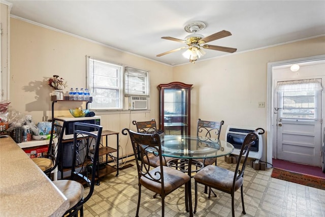 dining room featuring heating unit, cooling unit, crown molding, and ceiling fan