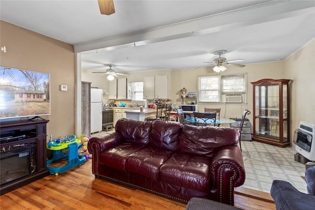 living room with cooling unit, ceiling fan, light hardwood / wood-style floors, and heating unit