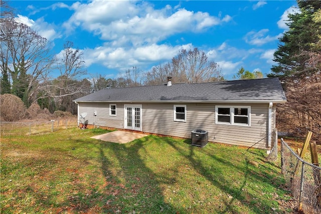 rear view of property featuring a patio, a lawn, french doors, and central air condition unit