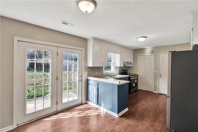 kitchen featuring appliances with stainless steel finishes, dark hardwood / wood-style flooring, a textured ceiling, and white cabinets