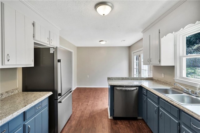 kitchen featuring sink, blue cabinetry, appliances with stainless steel finishes, white cabinetry, and a wealth of natural light