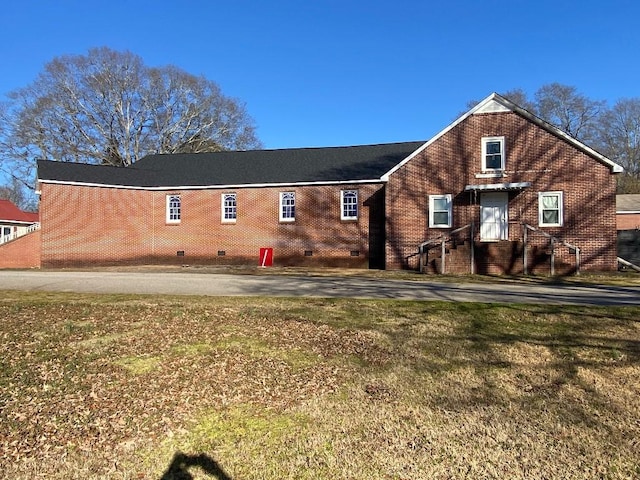 rear view of property featuring a lawn