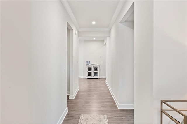 corridor with dark wood-type flooring and ornamental molding