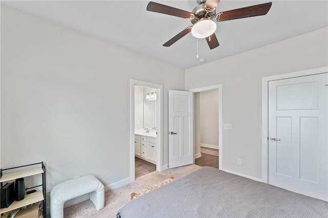 carpeted bedroom with ceiling fan and ensuite bath