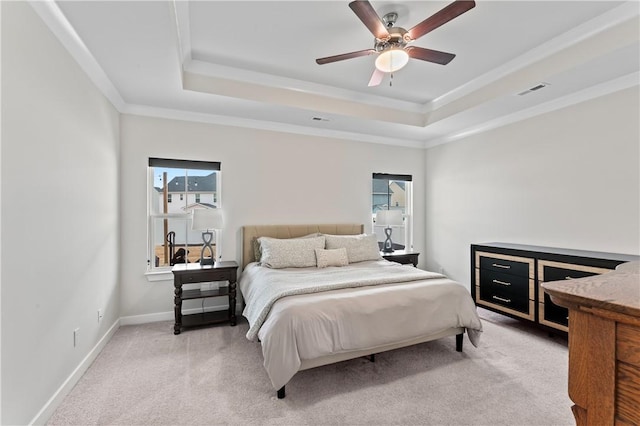 bedroom with crown molding, a tray ceiling, light colored carpet, and ceiling fan