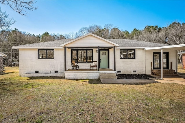 back of house featuring crawl space, brick siding, a lawn, and covered porch