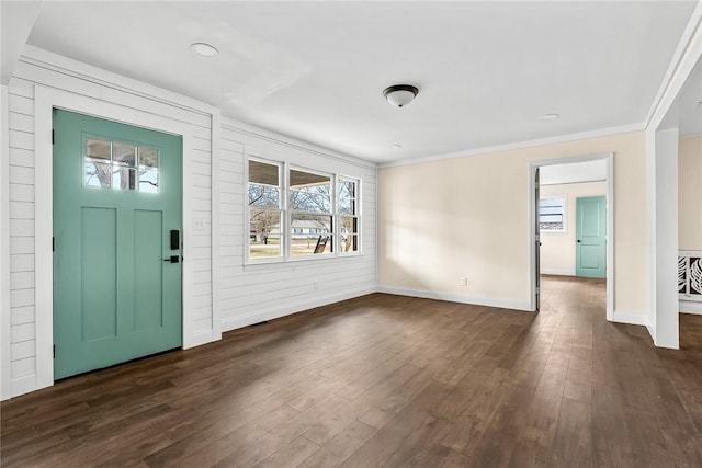 foyer with dark wood-style floors, ornamental molding, and baseboards