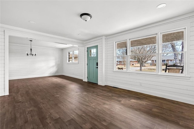 interior space featuring dark wood-style floors, a chandelier, a healthy amount of sunlight, and baseboards