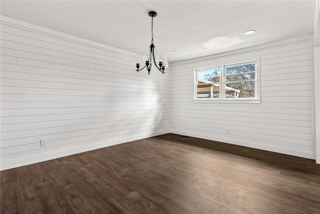 unfurnished dining area with baseboards, dark wood finished floors, and a notable chandelier