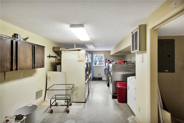 basement with electric panel, washer and dryer, and a textured ceiling