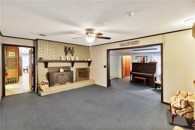 living room featuring ceiling fan, ornamental molding, and a textured ceiling