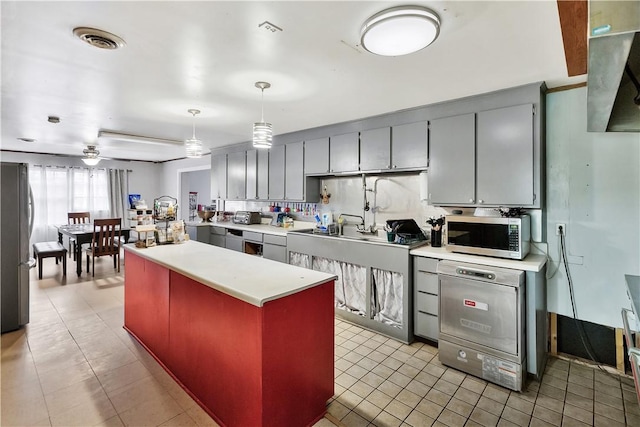 kitchen with gray cabinetry, appliances with stainless steel finishes, pendant lighting, ceiling fan, and backsplash