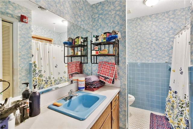 bathroom featuring tile patterned flooring, tile walls, vanity, a shower with curtain, and toilet