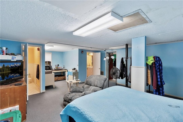 bedroom with carpet floors, a textured ceiling, and ensuite bath