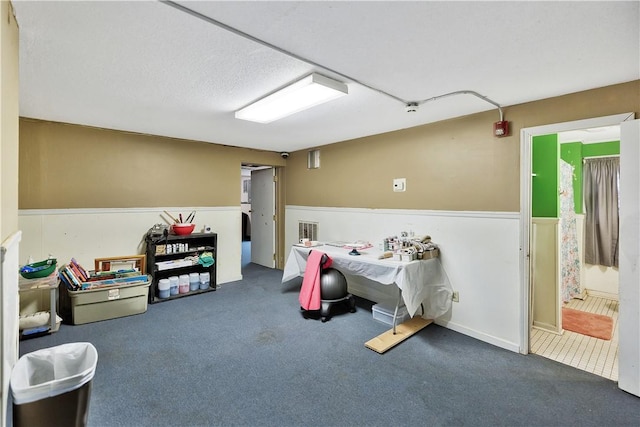 playroom with dark carpet and a textured ceiling