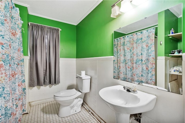 bathroom featuring curtained shower, sink, tile patterned flooring, toilet, and crown molding