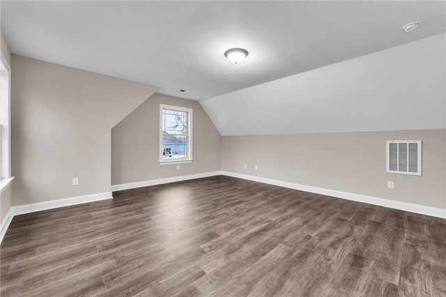 bonus room with vaulted ceiling and dark hardwood / wood-style flooring