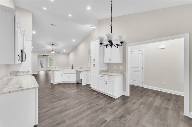 kitchen with dark wood-type flooring, light stone countertops, kitchen peninsula, and white cabinets