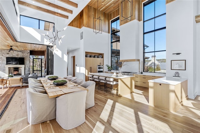 interior space featuring a healthy amount of sunlight, a stone fireplace, a center island, and light wood-type flooring