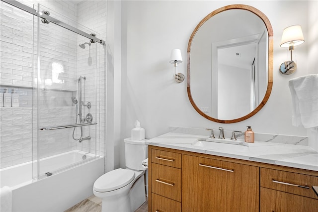 full bathroom featuring vanity, enclosed tub / shower combo, and toilet