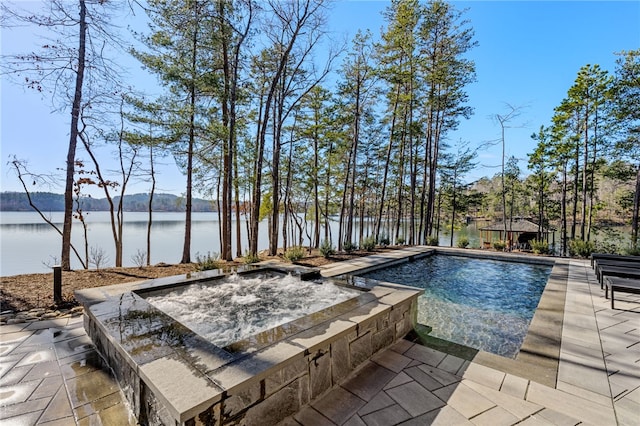 view of pool with a water view, an in ground hot tub, and a patio