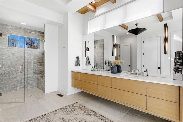 bathroom featuring a shower with door, vanity, and beam ceiling