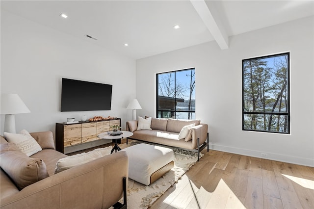 living room featuring beamed ceiling and light hardwood / wood-style flooring