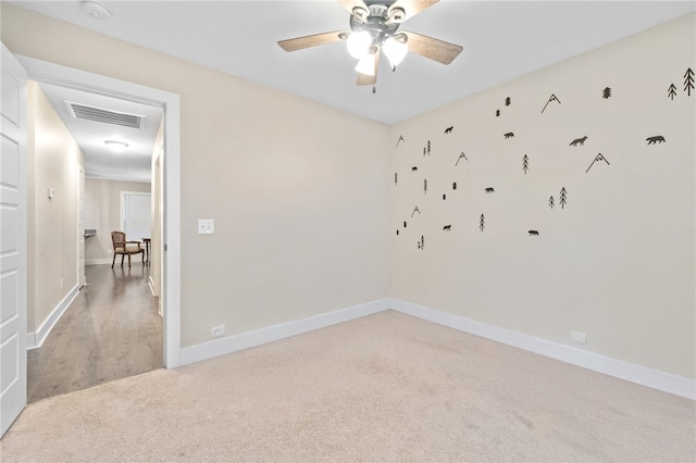 carpeted spare room with ceiling fan