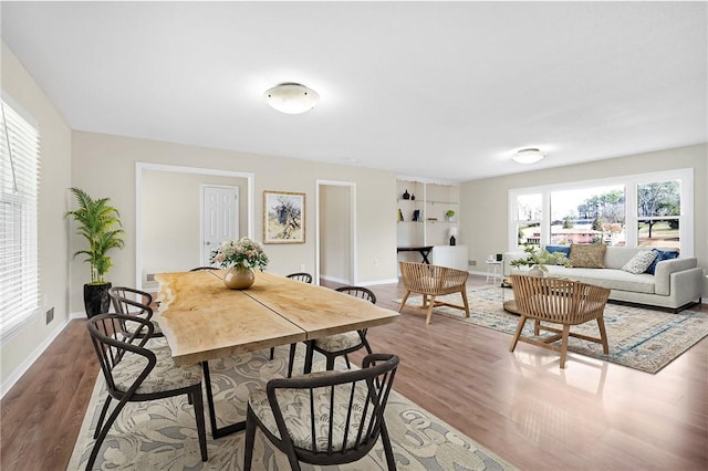 dining area with baseboards and light wood finished floors