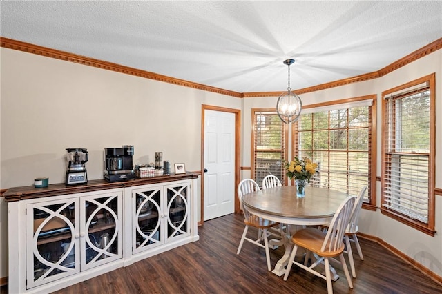 dining area featuring an inviting chandelier, dark hardwood / wood-style floors, a textured ceiling, and crown molding