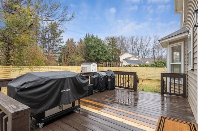 wooden terrace with a grill and a shed