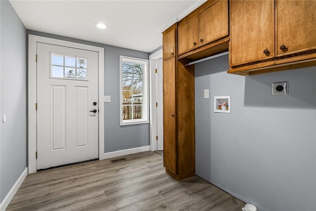 washroom featuring hookup for a washing machine, hookup for an electric dryer, cabinets, and light hardwood / wood-style flooring