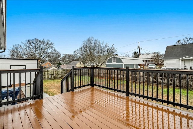 wooden terrace with a lawn and a storage unit