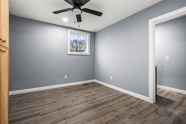 spare room with dark wood-type flooring and ceiling fan