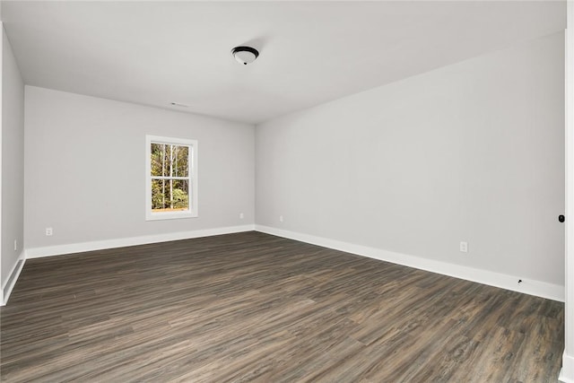 unfurnished room with dark hardwood / wood-style flooring