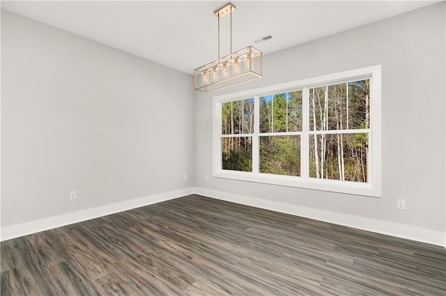 unfurnished dining area featuring plenty of natural light and dark hardwood / wood-style flooring