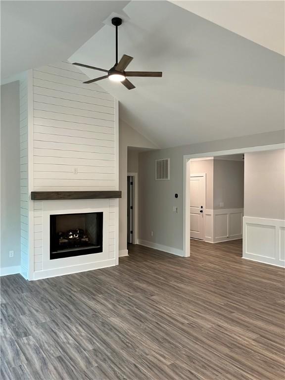 unfurnished living room with ceiling fan, a fireplace, dark hardwood / wood-style flooring, and vaulted ceiling