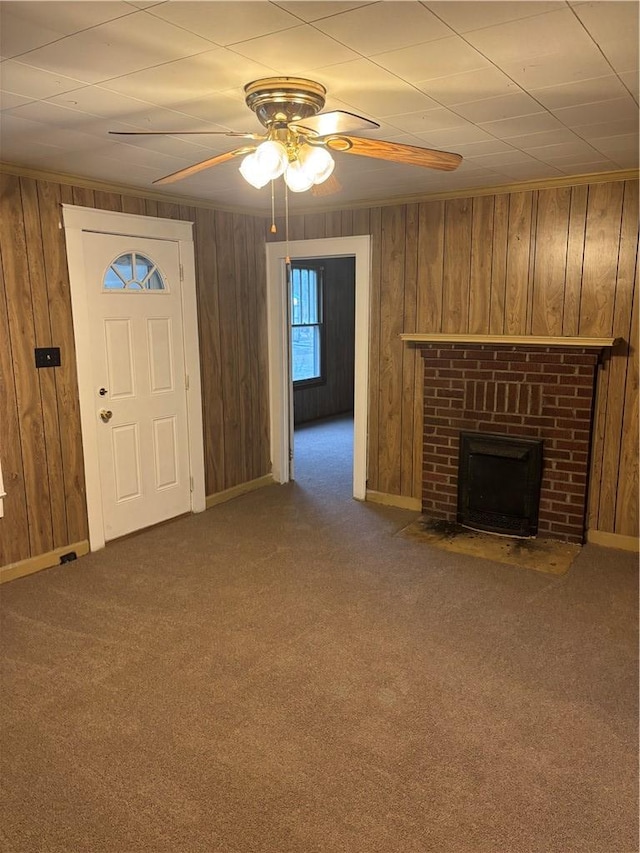 unfurnished living room featuring wooden walls, a fireplace, and carpet floors