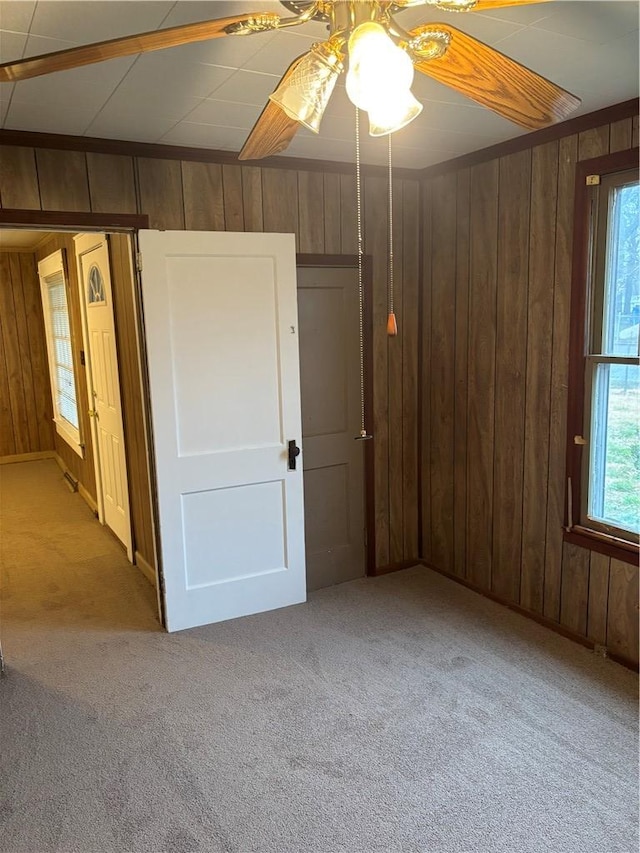 unfurnished bedroom featuring light colored carpet and wood walls