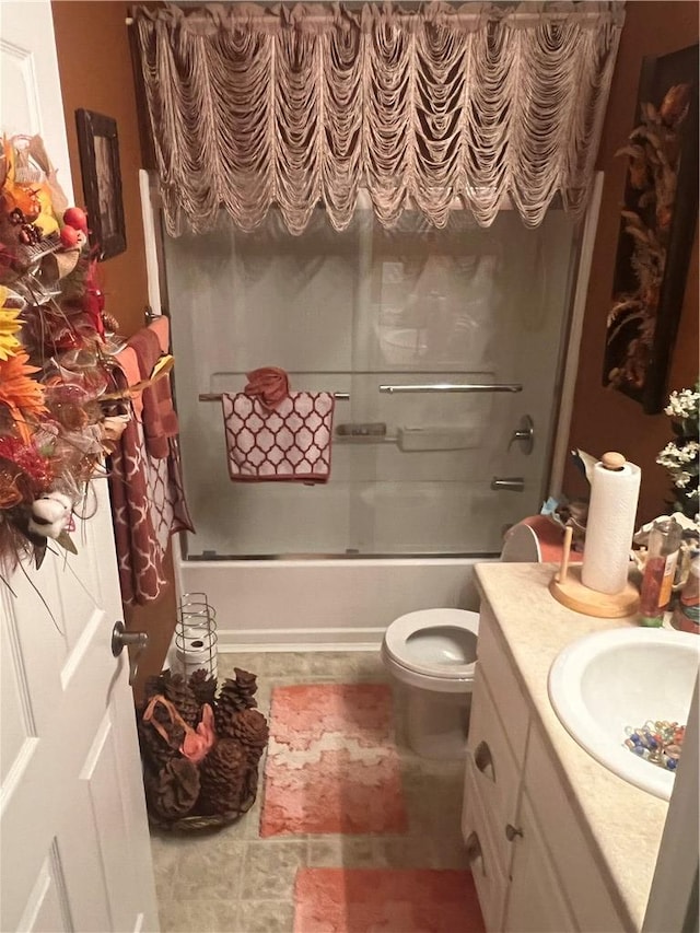 full bathroom featuring vanity, enclosed tub / shower combo, and toilet