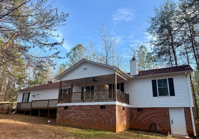 view of front of property with ceiling fan, a deck, and a chimney