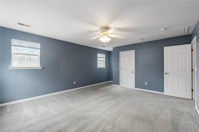 unfurnished bedroom featuring ceiling fan, light colored carpet, a closet, and a textured ceiling