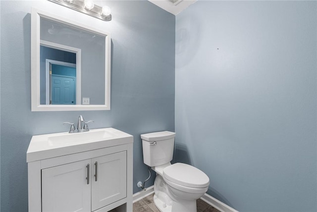 bathroom with hardwood / wood-style flooring, vanity, and toilet