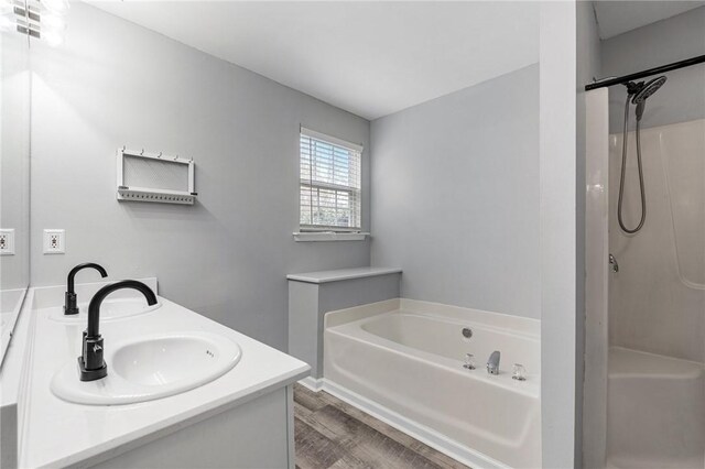 bathroom with vanity, hardwood / wood-style floors, and plus walk in shower