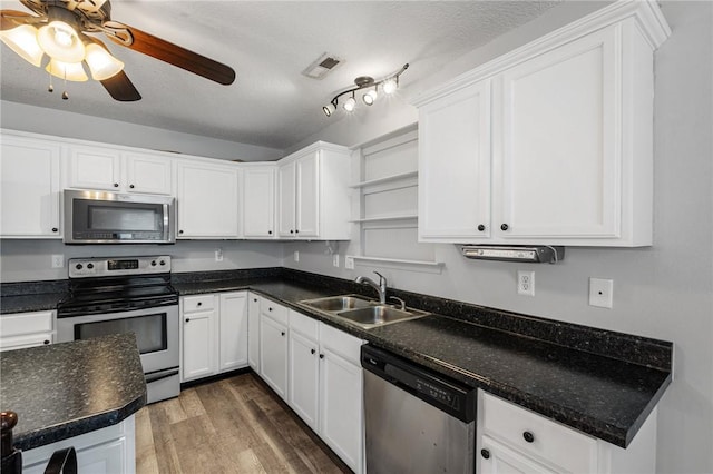 kitchen with white cabinetry, appliances with stainless steel finishes, dark wood-type flooring, and sink