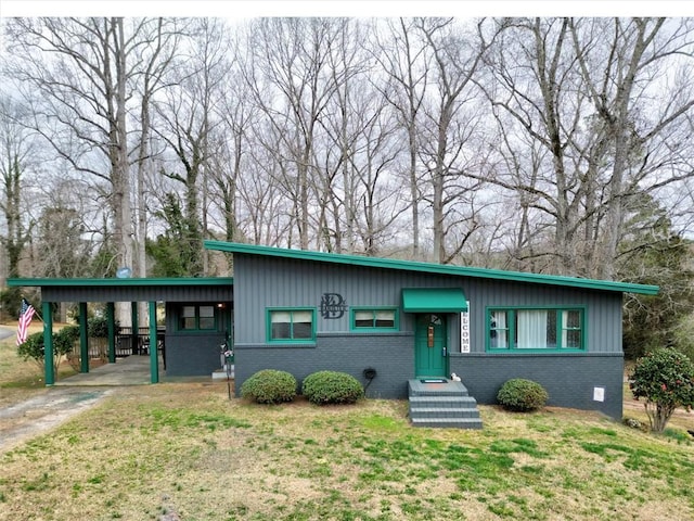 view of front of property with a front yard and a carport