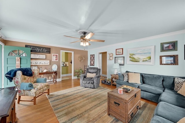 living room featuring wood-type flooring, ornamental molding, and ceiling fan