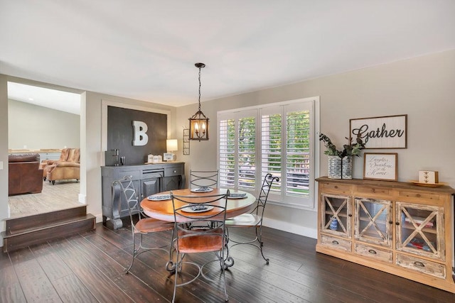 dining area with dark hardwood / wood-style floors and an inviting chandelier